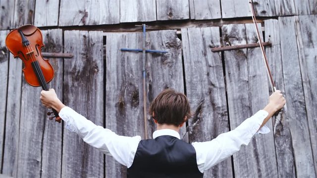 Person hold violin and bow high in the air 4K