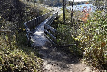 bridge over a creek crossing hiking and bicycling trail at the Fanshawe Nature Conservation area in London Ontario, Canada during Autumn