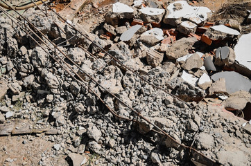 Debris of a demolished wall, demolition junk, steel structure, broken concrete and pieces of masonry brick.