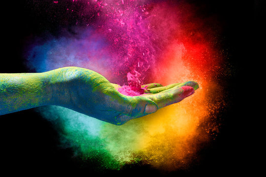 Magical rainbow colored dust exploding from a hand. Holi Festival