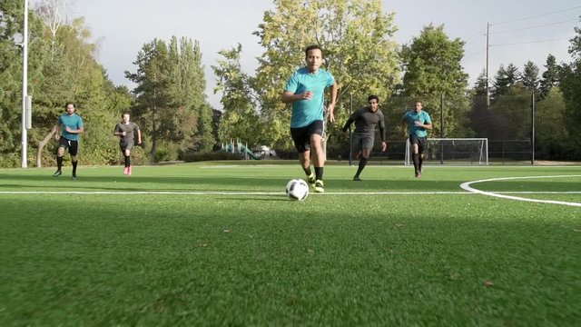 Male soccer players playing soccer.
