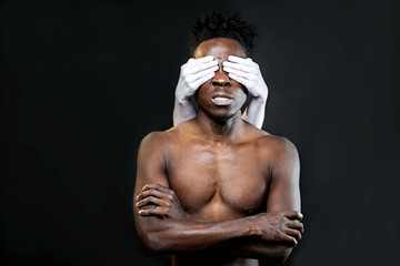 White hands close the eyes of a black man