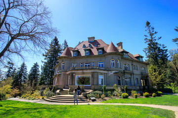Pittock Mansion, view on the house surrounded by trees from the garden on a beautiful sunny spring...