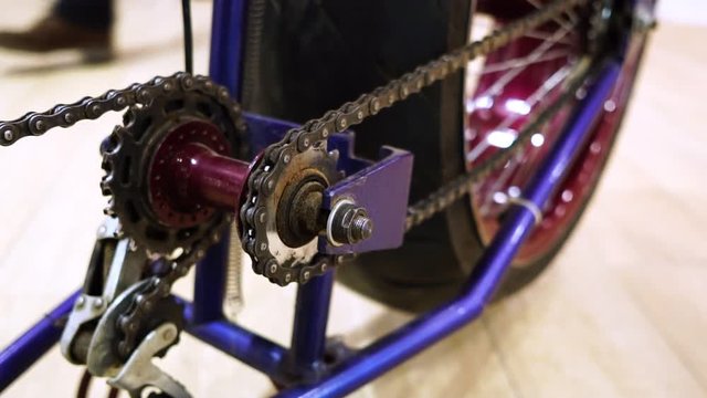 A Bicycle with a large rear wheel, drive system chain closeup