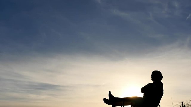Laying relaxed man silhouette on sky background time lapse