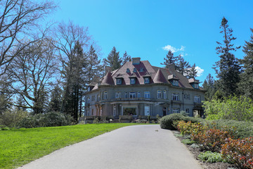 Fototapeta na wymiar Pittock Mansion, view on the house surrounded by trees from the garden on a beautiful sunny spring day, Portland