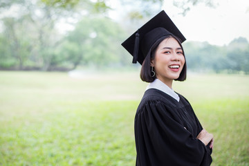 Portrait of young asian woman outside the building on her graduated day. Cute asian girl with her...