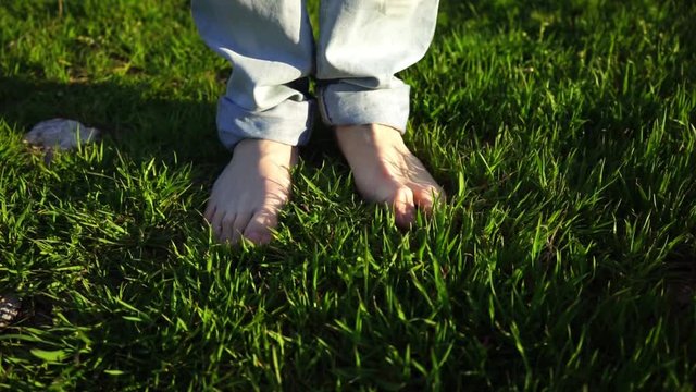 Hombre joven moviendo sus pies sobre hierba 