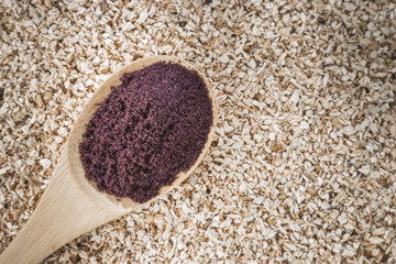 Acai powder in bowl on wooden background