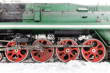 Fototapeta na wymiar red wheel and detail of mechanism a vintage russian steam train locomotive