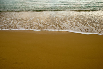 Waves on the seashore on the golden sand