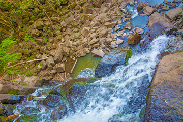 view from the top of the waterfall falling down, forest landscape with a waterfall, where begins...
