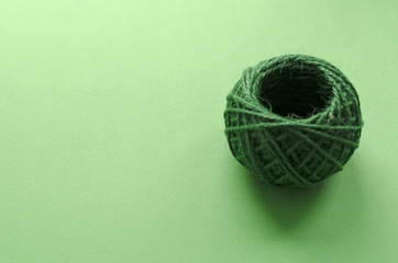 ball of green threads on green paper background