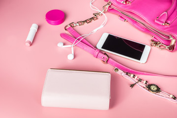 Top view of Women bag and lady stuff with copyspace on pink background, vigtage effect photo