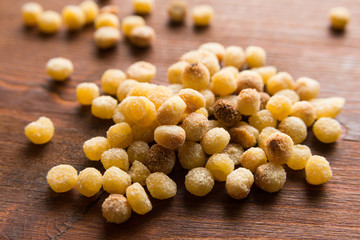 Fregola sarda cruda su tavolo in legno, raw fregola on wood board, typical Sardinian Pasta