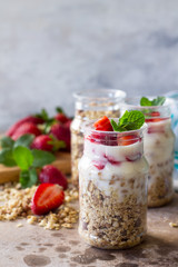Homemade healthy breakfast with homemade baked granola, fresh strawberry and yogurt on stone or concrete table. Copy space.