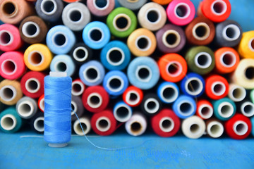 Colored thread on a wooden table for sewing close-up. Art soft focus.
