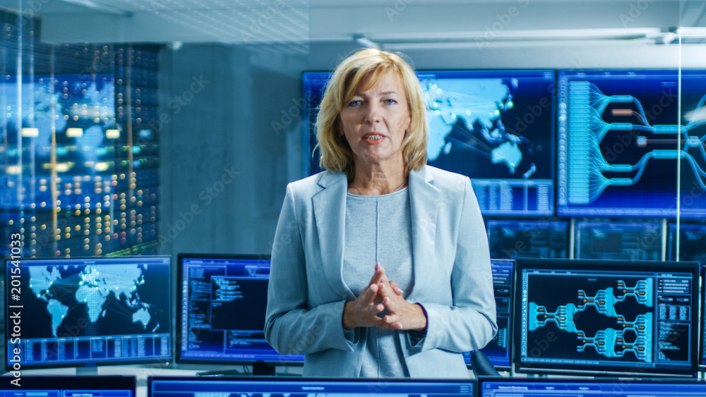 Leinwandbilder In the System Control Room Female Chief Engineer Describes Her Project Talking into the Camera. In the Background Multiple Screens Showing Interactive Data.