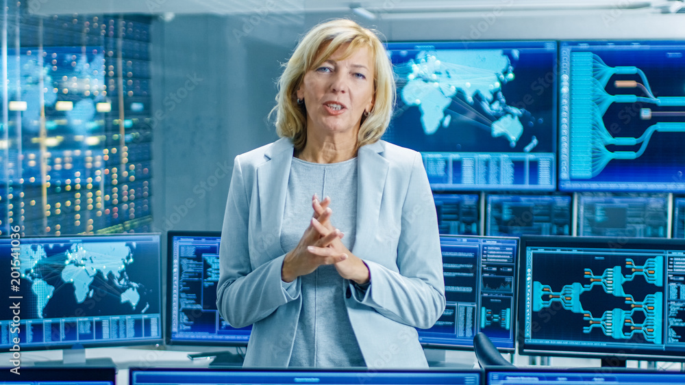 Poster In the System Control Room Female Chief Engineer Describes Her Project Talking into the Camera. In the Background Multiple Screens Showing Interactive Data.