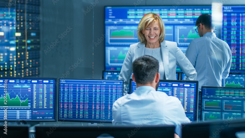 Poster in the stock market selling/ buying department female manager talks with male trader and smiles. in 
