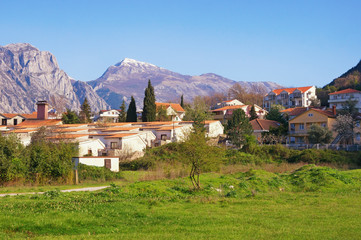 Fototapeta na wymiar Spring Mediterranean landscape. Montenegro, view of town of Prcanj and snow-capped mountains of Lovcen