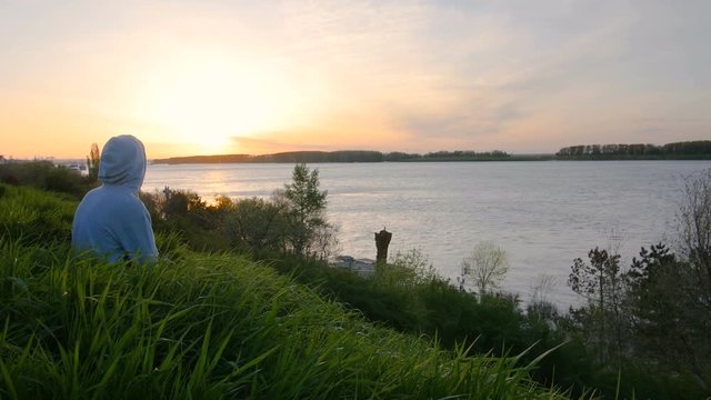 Watching The Sunrise Above Water From A Hill