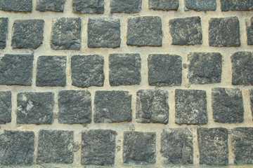 Sidewalk black square tile. Cobblestone paving. Background. Texture.