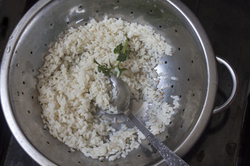 poured cooked rice in an old colander close