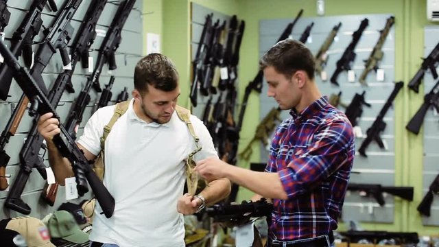 positive young men choosing air weapon in military shop