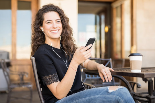 Woman enjoying listening music at cafe