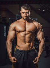 Fototapeta na wymiar european caucasian athletic man bodybuilder showing his muscular body. man with big arms looking at camera. Biceps workout clouse-up. bodybuilders portrait