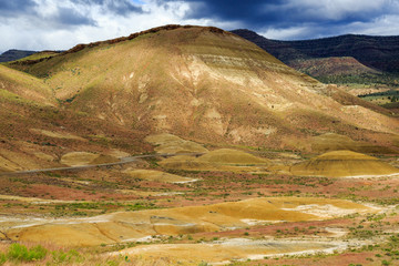 Fototapeta premium North America, United States, Oregon, Central Oregon, Redmond, Bend, Mitchell. Series of low clay hills striped in colorful bands of minerals, ash and clay deposits.
