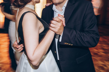 happy stylish people dancing and having fun at wedding reception in restaurant. guests dancing in light, people in motion at party in club