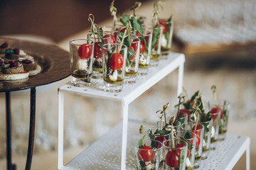 delicious appetizers starters with tomatoes and cheese in glass on plate on table at wedding reception. luxury catering at celebrations