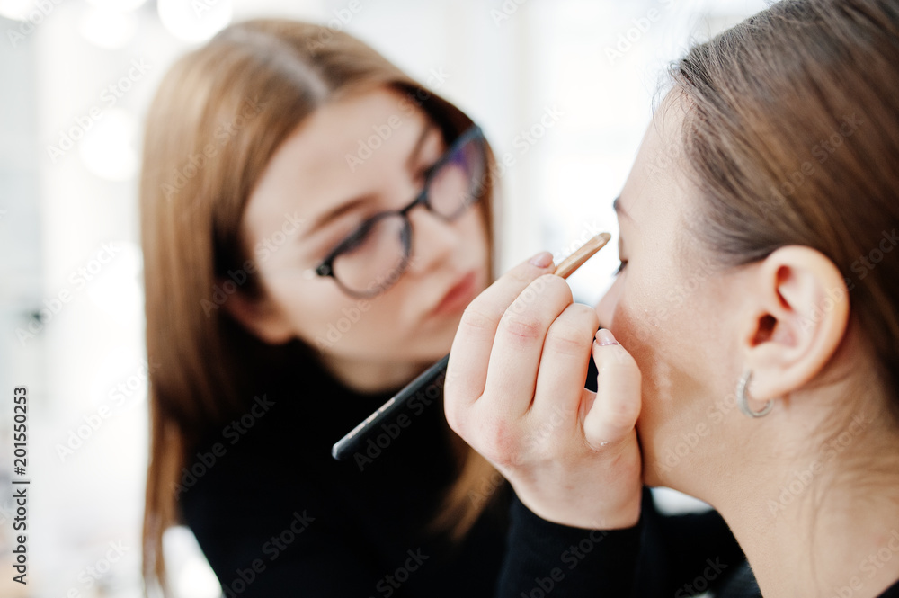 Wall mural make up artist work in her beauty visage studio salon. woman applying by professional make up master