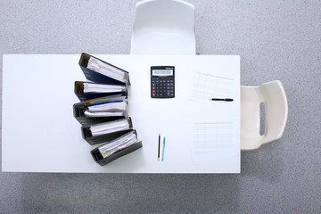 Binders with papers are waiting to be processed with bookkeeper. Internal Revenue Service inspector...