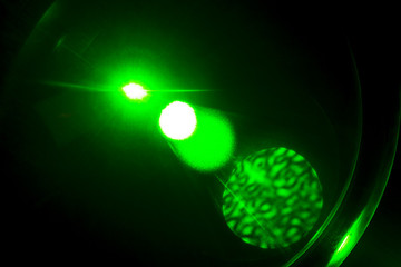 Camera lens flare by laser light create hexagons of objective iris shapes of number depending on number of lens surface and interferent effect and moire on digital sensor on dark black background