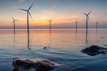 Sun setting over the water in Holland with red light full of rigging marks in the sky