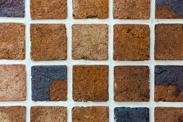 Tiles of house facade, gray and brown brick wall background.