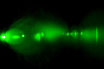 Camera lens flare by laser light create hexagons of objective iris shapes of number depending on number of lens surface and interferent effect and moire on digital sensor on dark black background