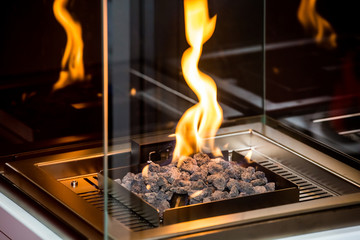 Decorative artificial fireplace with white stones in room interior