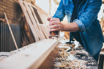 Carpenter At Work Using Jointer Plane.