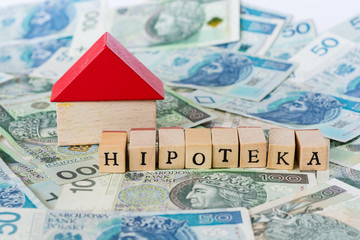 Word mortgage written in polish with wooden blocks standing on money