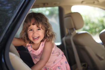 Little girl looks happy in the car