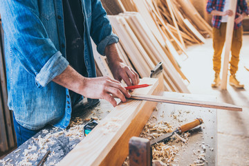 Young carpenter constructing and measuring wood