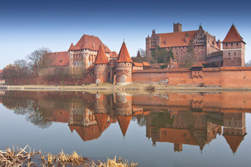 Naklejka na ściany i meble Malbork Castle and reflection in River Nogat, Poland.