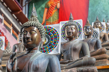 Statues of the Buddha in the lotus position, Gangaramaya Buddhist Temple, Colombo, Sri Lanka.