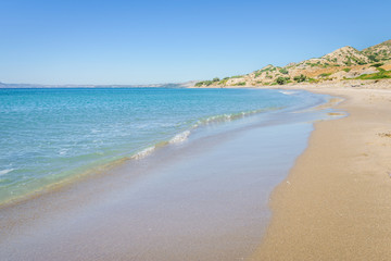 Relaxing at the greek mediterranean sea and feeling the smooth life of greece behind a green plant wall at a golden sandy robinson crusoe beach, Southcoast, Kos Island, Dodecanese, Greece