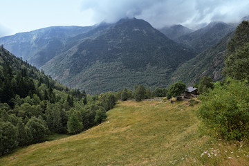 Fototapeta premium Prado entre montañas en un dia parcialmente nublado.