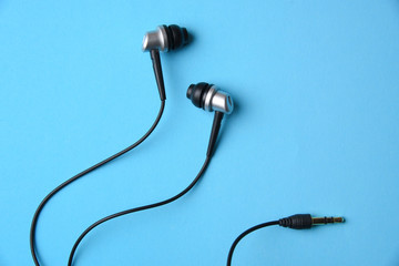 Headphones on blue background, flat lay, copy space